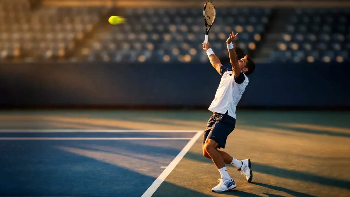 Professioneller Tennisspieler beim kraftvollen Aufschlag auf einem Hartplatz mit dramatischer Beleuchtung